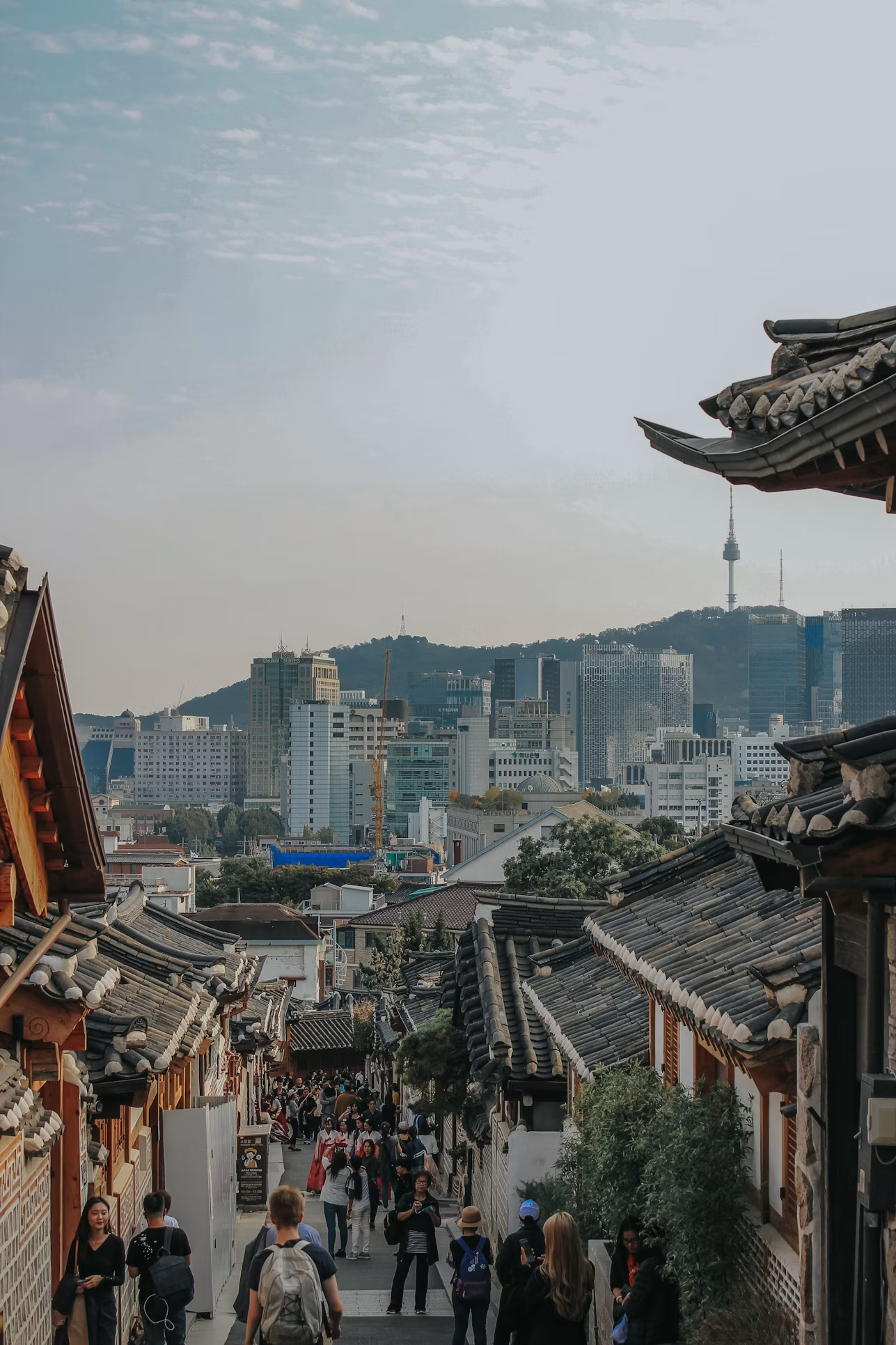 首尔韩屋街巷,层叠的瓦屋檐与远处南山上的首尔塔